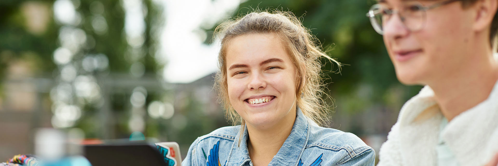 Een student lacht naar de camera