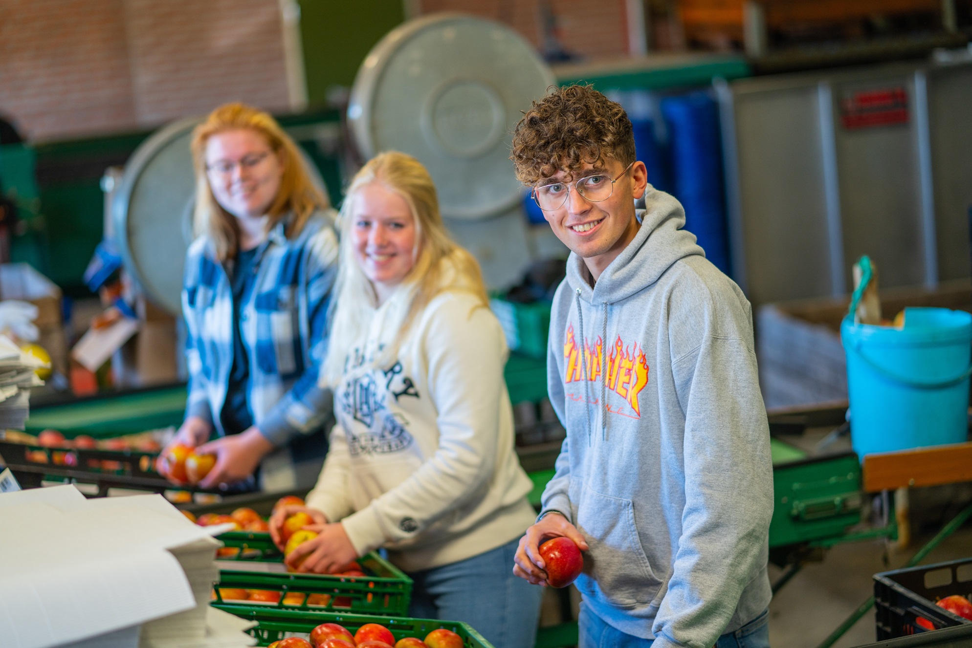 Studenten staan bij fruitmanden