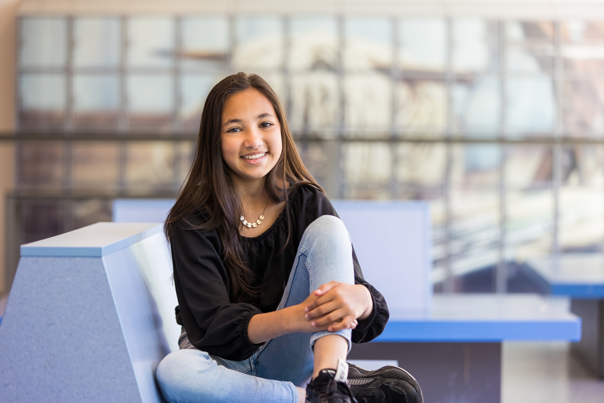 Meisje zittend op een bank voor kluisjes