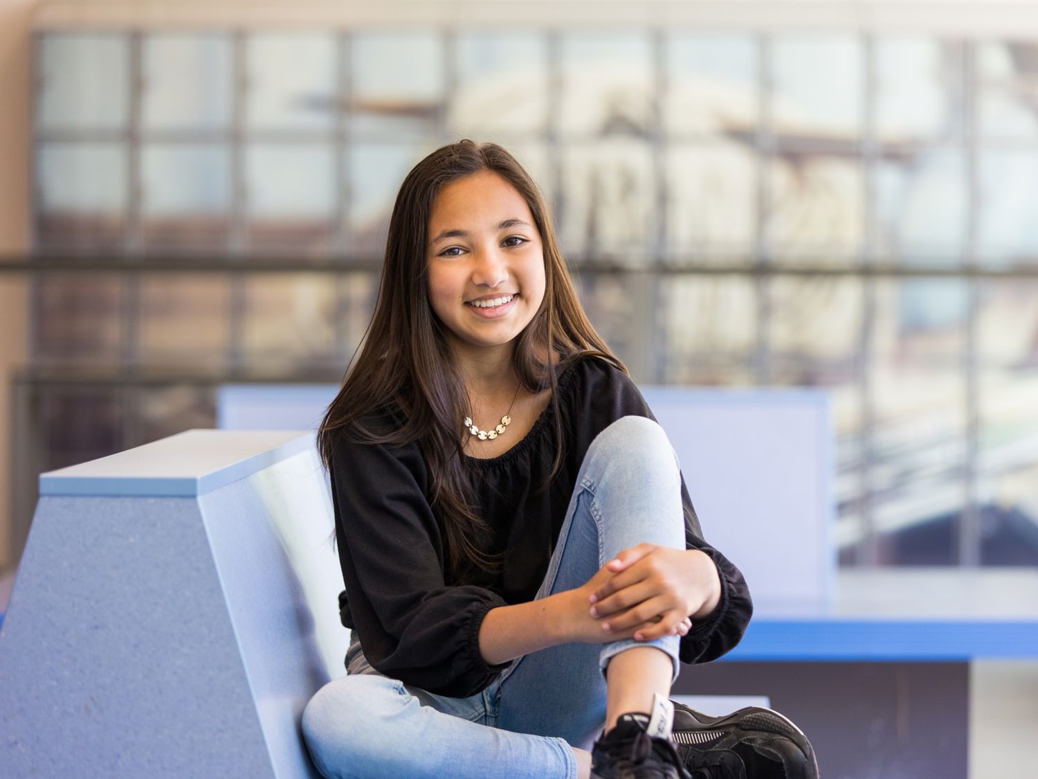 Meisje zittend op een bank voor kluisjes