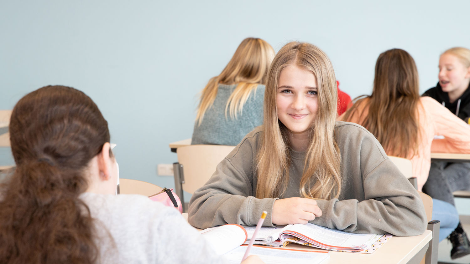 Meisje zittend op een bank voor kluisjes