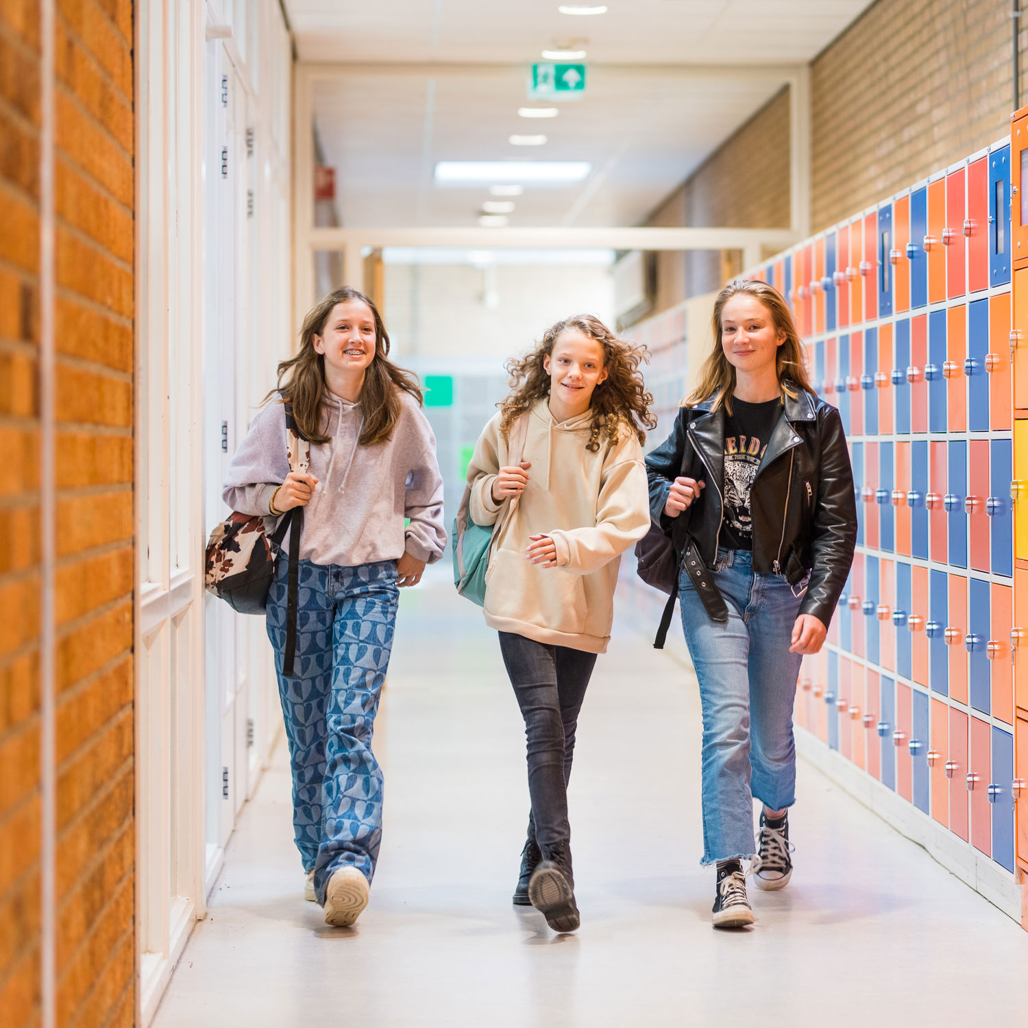 Meisje zittend op een bank voor kluisjes