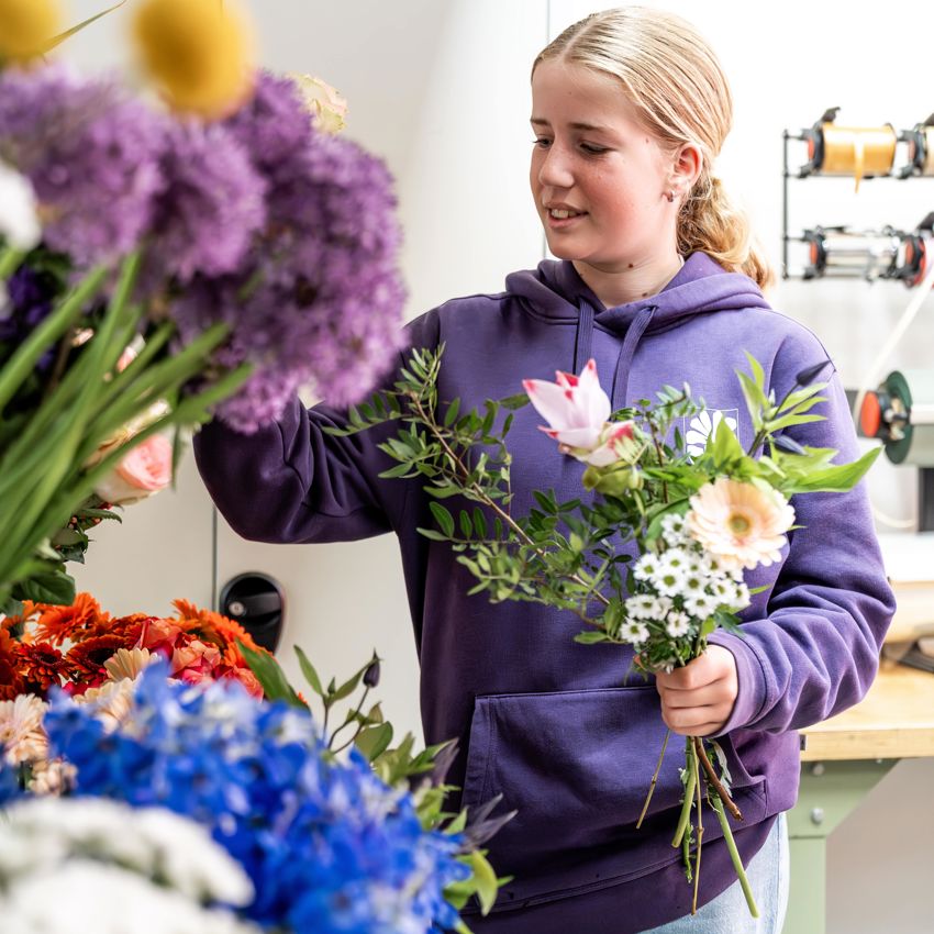 Meisje zittend op een bank voor kluisjes