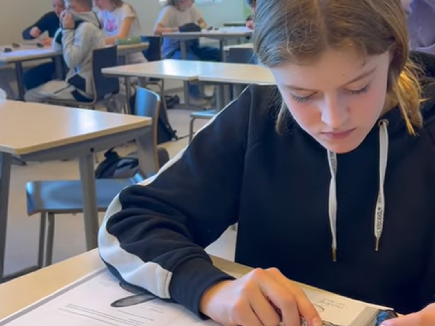 Leerling lachend voor een boekenkast