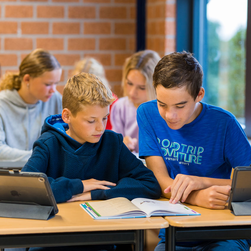 Docent leidt groep lachende studenten in klaslokaal