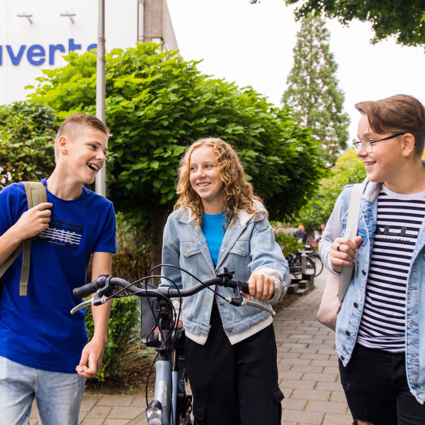 Docent leidt groep lachende studenten in klaslokaal