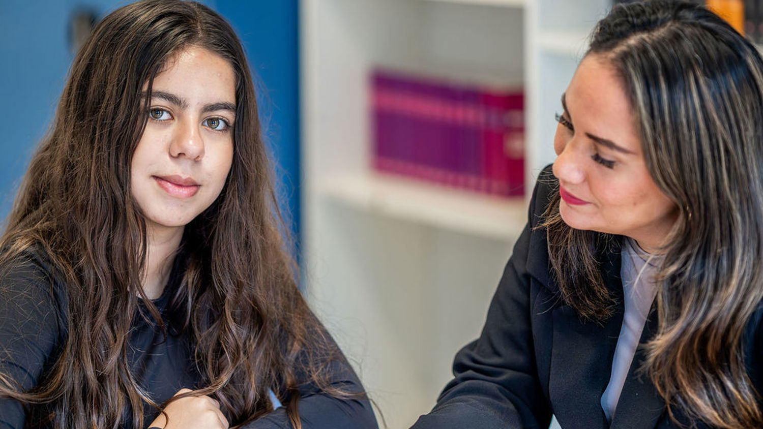 Meisje zittend op een bank voor kluisjes