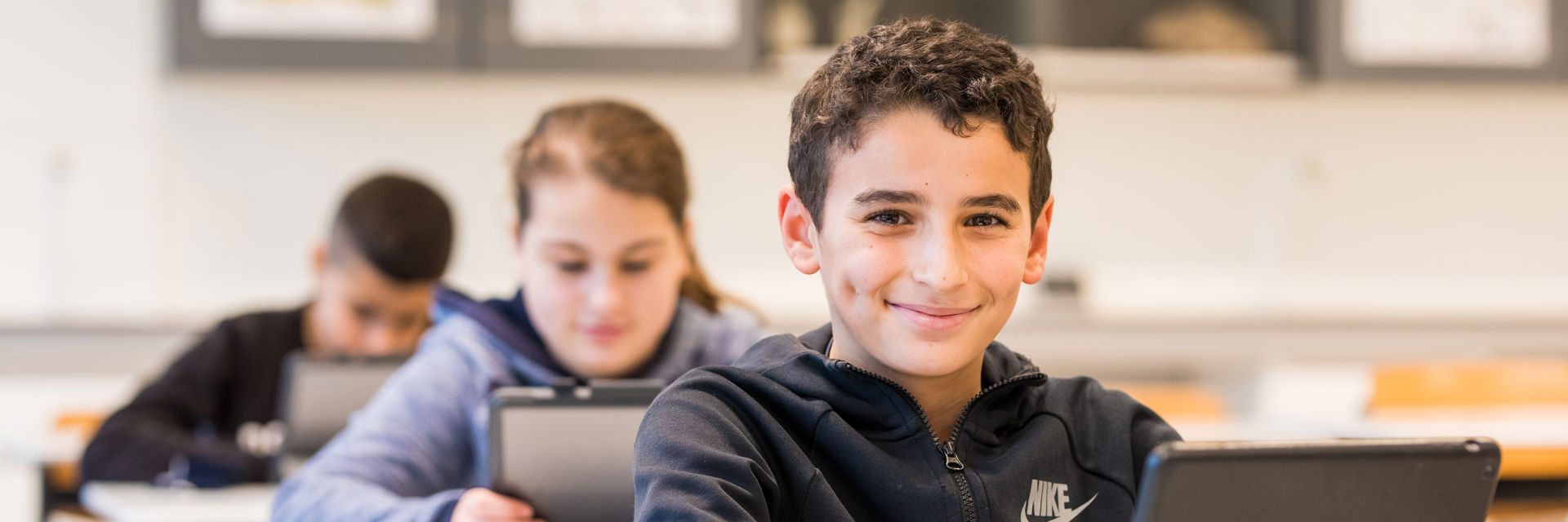 Jongen met iPad in klaslokaal