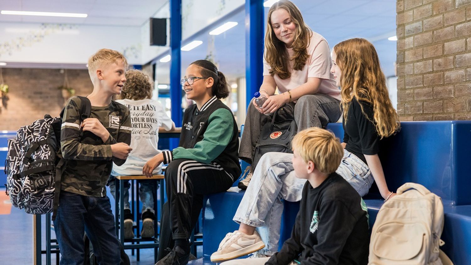 Meisje zittend op een bank voor kluisjes