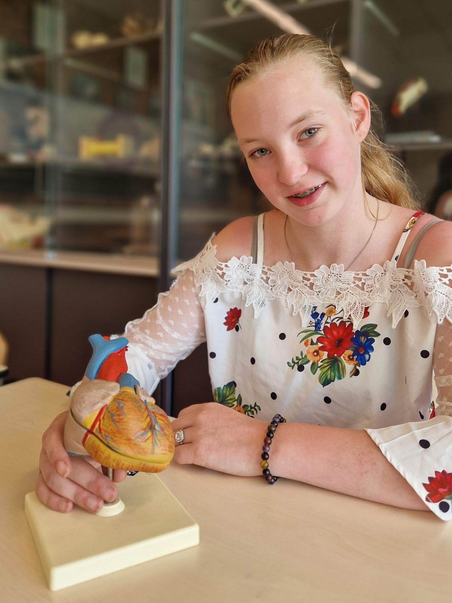 Meisje zittend op een bank voor kluisjes