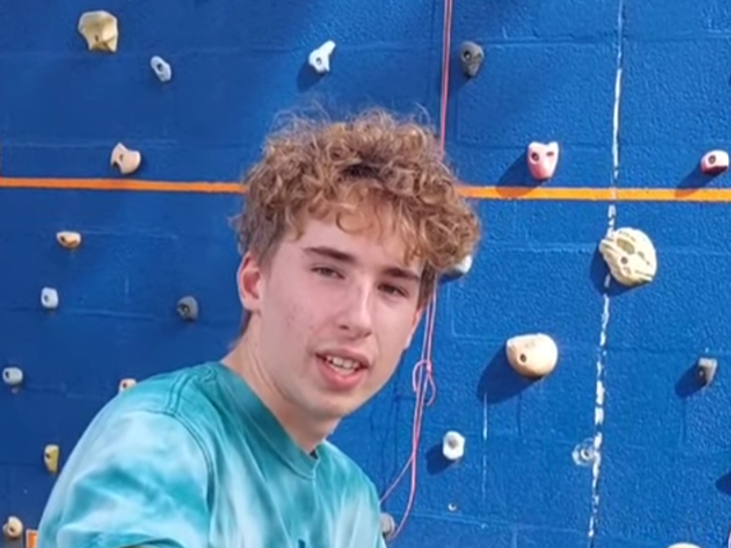 Leerling lachend voor een boekenkast