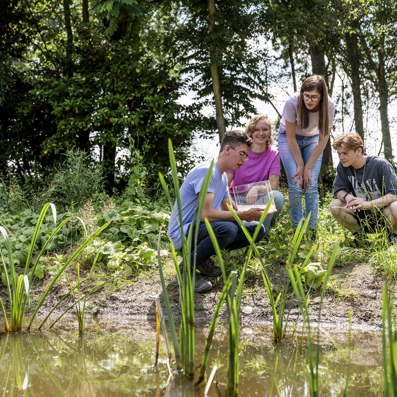 Docent leidt groep lachende studenten in klaslokaal