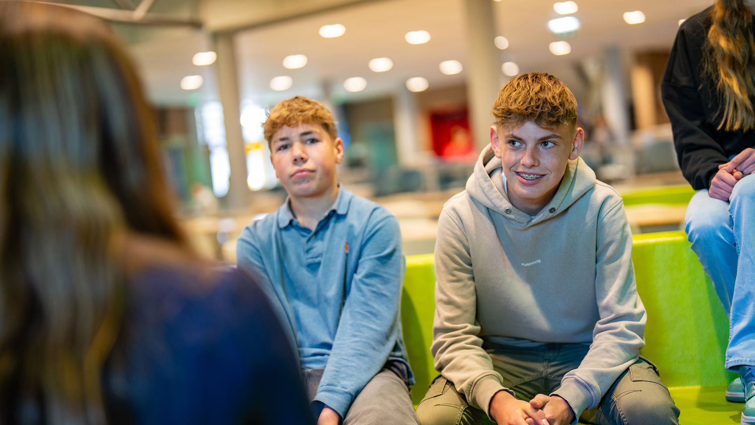 Meisje zittend op een bank voor kluisjes