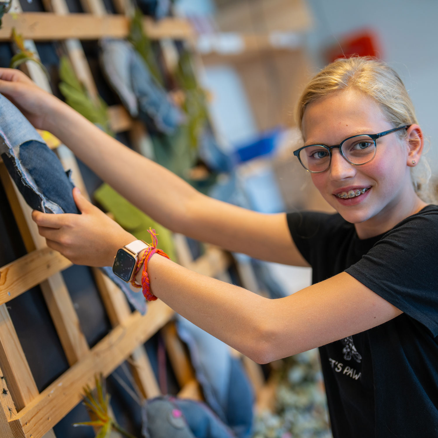 Leerling lachend voor een boekenkast