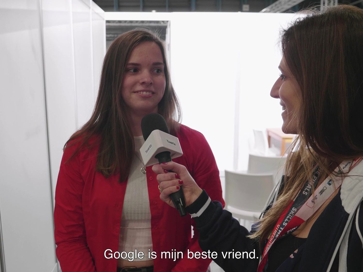 Leerling lachend voor een boekenkast