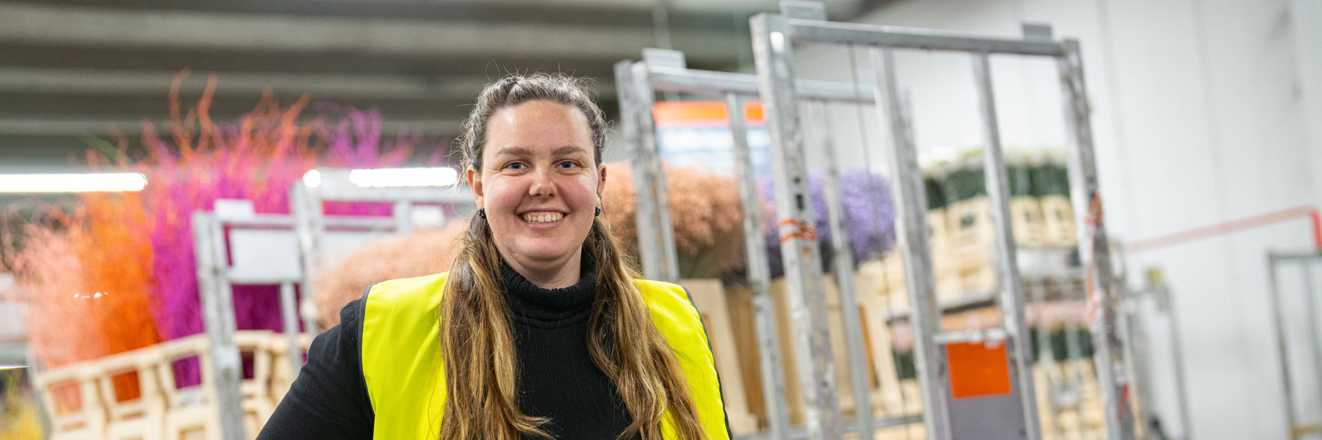 Een studente in een logistiek centrum met bloemen