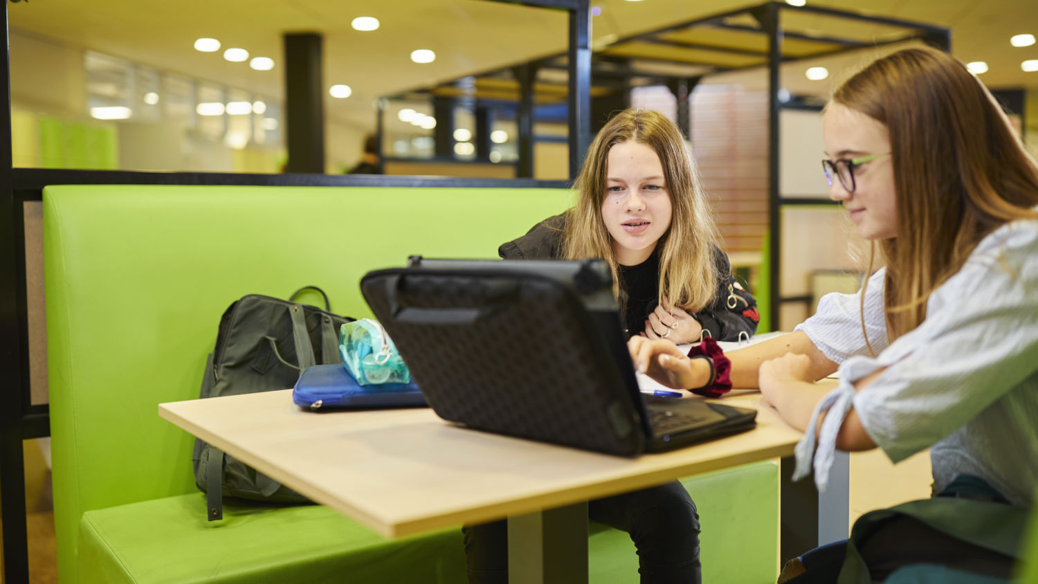 Meisje zittend op een bank voor kluisjes