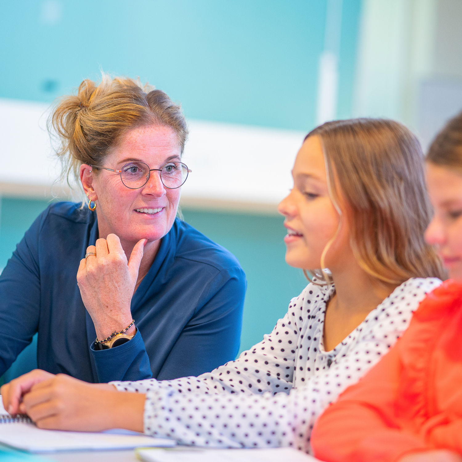 Docent leidt groep lachende studenten in klaslokaal