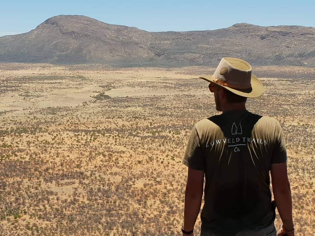 Jonge man kijkt uit over een natuurgebied in Afrika